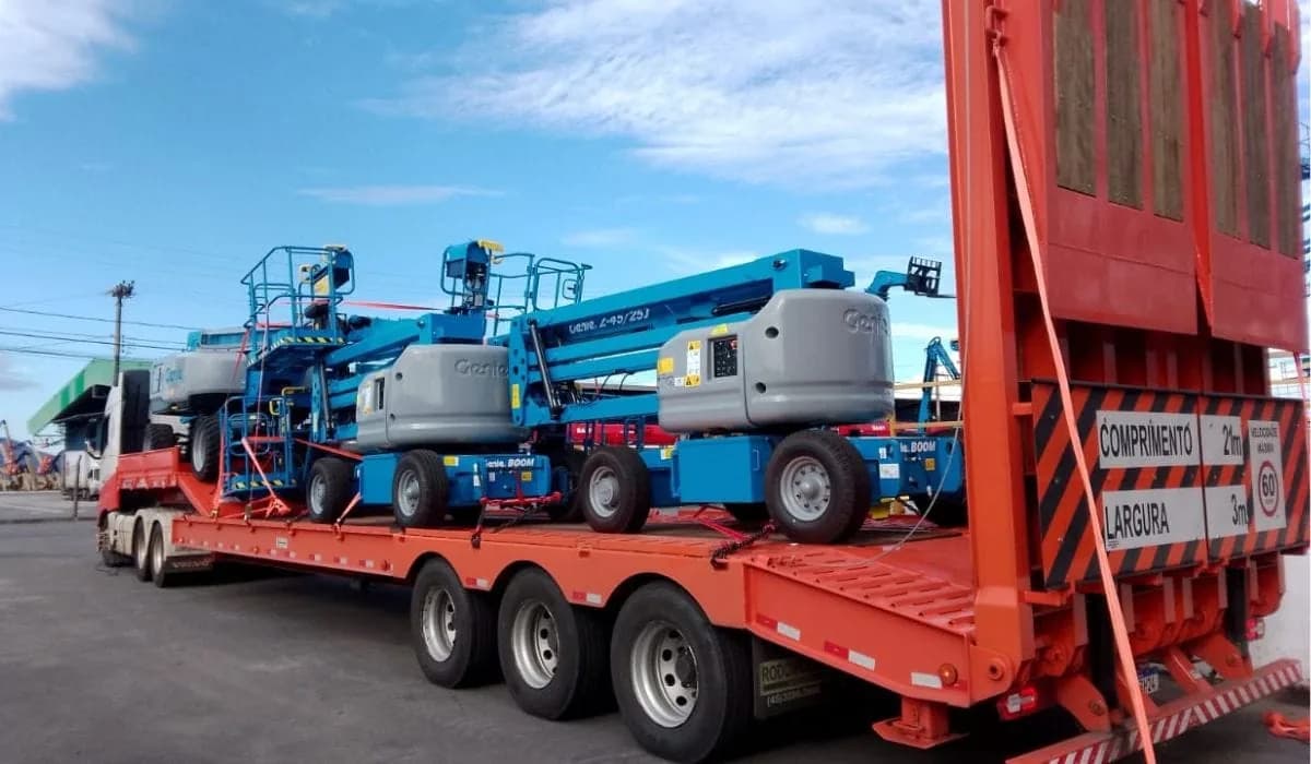 Carreta do Grupo APC carregada com várias plataformas elevatórias, pronta para sair