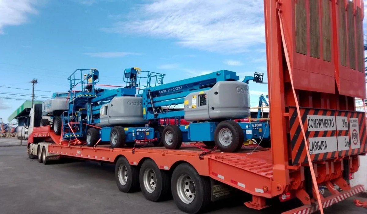 Carreta do Grupo APC carregada com várias plataformas elevatórias, pronta para sair